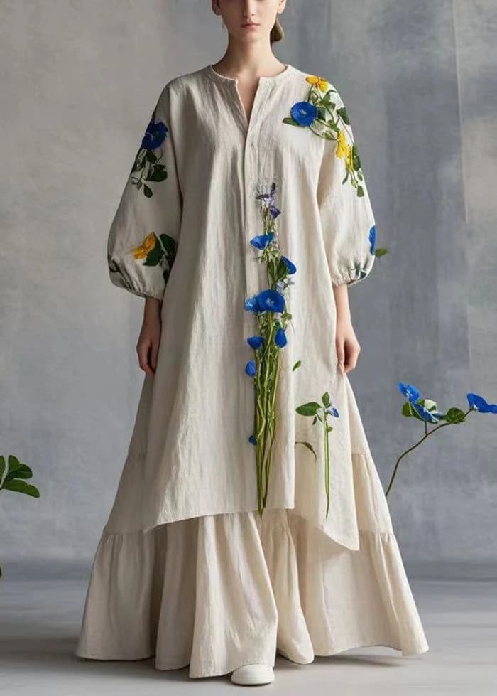 A long cream dress with full sleeves and flowers embroidered down the front