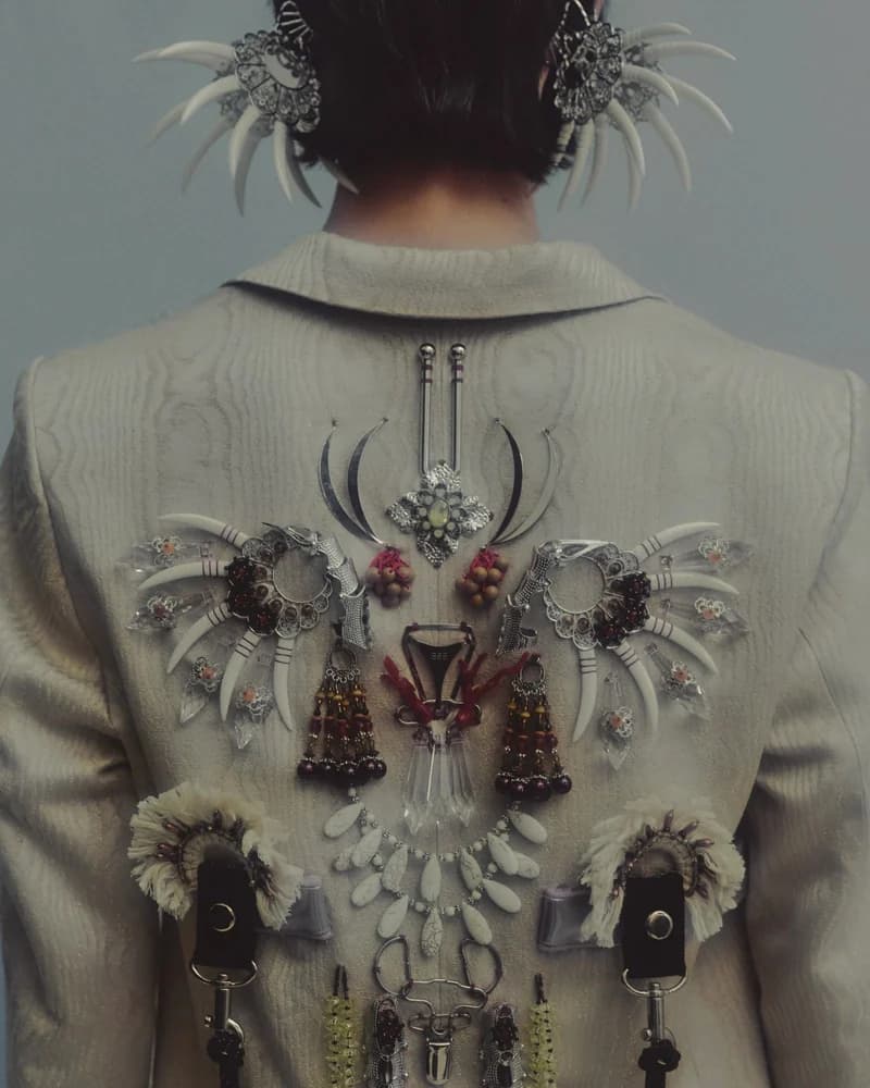 The back of a pale jacket decorated with reclaimed beads, claws and hardware